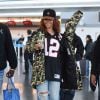Rihanna à l'aéroport JFK de New York, porte une vasquette et une doudoune Puma (collection Bape FC de Bape et Puma), un maillot de football des Atlanta Falcons, un jean et des chaussures Prada. Le 1er mai 2015.