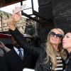Paris Hilton arrive à la gare de Liverpool, le 13 mai 2015. Elle prend le temps de poser avec ses fans et avec une statue !. 