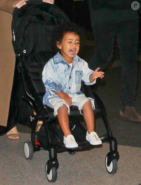 Kim Kardashian arrive avec son mari Kanye West et leur fille North à l'aéroport de LAX à Los Angeles, le 16 avril 2015