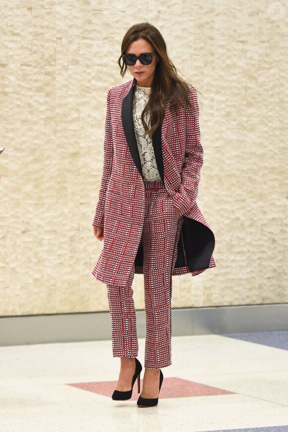 Victoria Beckham arrive à l'aéroport JFK à New York, habillée d'un manteau, d'un top brodé et d'un pantalon Victoria Beckham (pré-collection été 2016). Le 31 mai 2015.