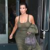 Kim Kardashian, enceinte, quitte son appartement de SoHo habillée d'une robe kaki Faith Connexion et chaussée de sandales Hermès. Une veste également kaki et un sac Givenchy (modèle mini Pandora) complètent sa tenue. Le  2 juin 2015.