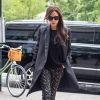 Victoria Beckham à New York, porte un manteau, un pull et une pochette noirs (manteau et pochette Victoria Beckham), un pantalon à motifs floraux Victoria Beckham et des chaussures Casadei. Le 4 juin 2015.