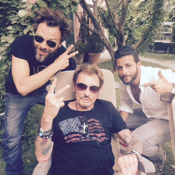 Quelques heures avant de monter sur scène aux arènes de Nîmes, Johnny Hallyday se détend à son hôtel avec ses amis Christophe Maé et Maxim Nucci. À Nîmes, le 2 juillet 2015.