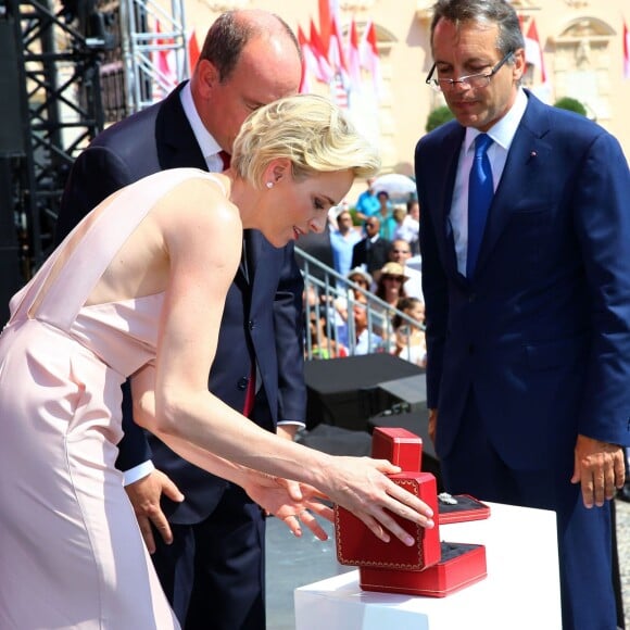 La princesse Charlene et le prince Albert II de Monaco ont reçu samedi 11 juillet 2015 lors de la célébration des dix ans de l'avènement du souverain monégasque les cadeaux faits par les Monégasques à leurs jumeaux Jacques et Gabriella à l'occasion de leur baptême : une broche et une montre Cartier des années 1920.