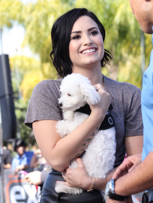 Demi Lovato se rend, accompagnée de son petit caniche blanc, à l'émission "Extra" de Mario Lopez pour une interview à Universal City, le 3 mars 2015