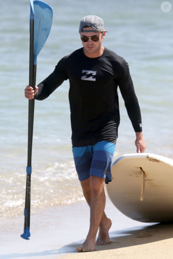 Zac Efron fait du paddle avec des amis sur une plage à Hawaii, le 23 mai 2015.