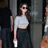 Selena Gomez quitte un Starbucks à New York, habillée d'un pull court et d'une jupe plissée Topshop, et de mules Kurt Geiger. La chanteuse de 23 ans porte également des lunettes Christian Dior. Le 19 août 2015.