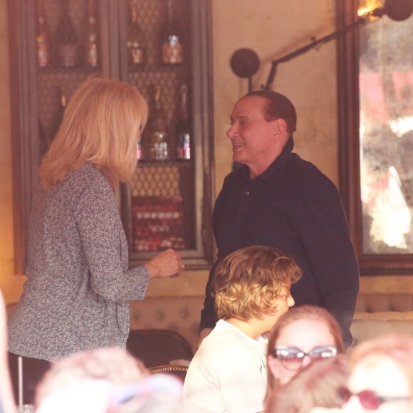 Exclusif - Amanda Lear est folle de joie de retrouver Silvio Berlusconi alors qu'il déjeune dans un restaurant avec sa famille (sa fille Marina et ses deux petits-fils Gabriele et Silvio) à Saint-Tropez, le 11 août 2015.