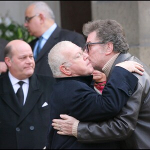 Michel Charasse et Eddy Mitchell s'embrassent aux obsèques de Carlos à Paris, le 21 janvier 2008.