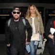 Cameron Diaz et son mari Benji Madden lors de leur arrivée à l'aéroport LAX de Los Angeles, le 31 août 2015. Cameron Diaz dissimulerait son ventre pour couvrir une supposée grossesse...