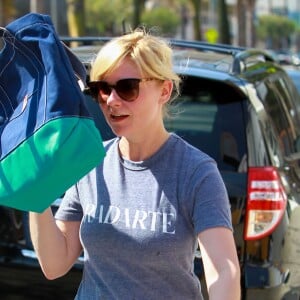 Kirsten Dunst essaie de se cacher des photographes à la sortie de son cours de gym à Studio City, le 10 octobre 2014.