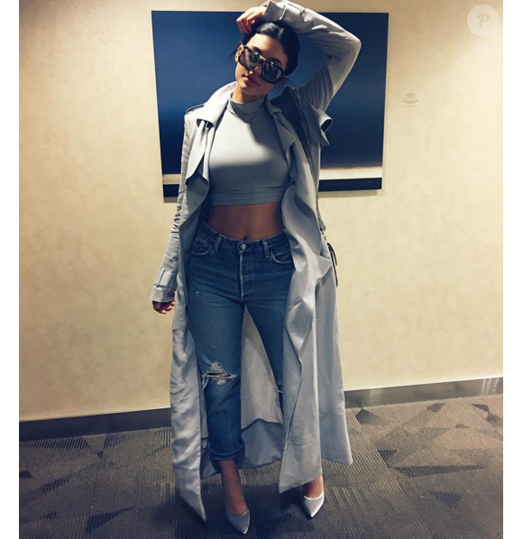 Kylie Jenner, sexy dans son trench-coat Haider Ackermann porté avec un crop top gris, un jean et des chaussures Gianvito Rossi. New York, le 29 octobre 2015.