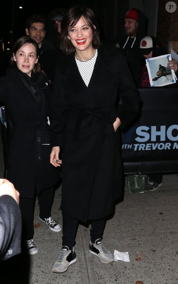 Marion Cotillard se fait offrir un petit sapin de Noël de la part d'un fan à la sortie de l'émission 'Daily Show with Trevor Noah' à New York, le 9 décembre 2015.