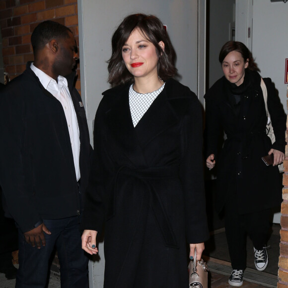 Marion Cotillard se fait offrir un petit sapin de Noël de la part d'un fan à la sortie de l'émission 'Daily Show with Trevor Noah' à New York, le 9 décembre 2015.
