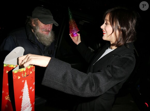 Marion Cotillard reçoit un cadeau du célèbre SDF Radioman à New York le 9 décembre 2015.