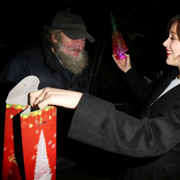 Marion Cotillard reçoit un cadeau du célèbre SDF Radioman à New York le 9 décembre 2015.