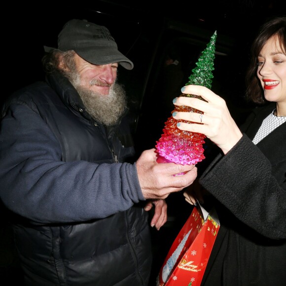 Marion Cotillard reçoit un cadeau du célèbre SDF Radioman à New York le 9 décembre 2015.