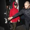 Justin Bieber quitte le Club "Nice Guy" de West Hollywood, souriant avec un sweat rouge à capuche le 15 décembre 2015.