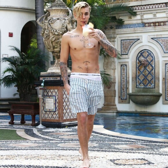 Exclusif - Prix spécial - Justin Bieber se relaxe avec des amis au bord de la piscine de la 'Versace Mansion’ en buvant un cocktail à Miami, le 9 décembre 2015