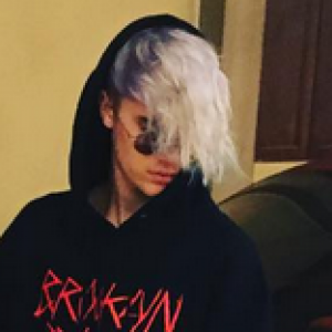 Justin Bieber pose, assis sur sa Ferrari rouge, et présente sa nouvelle coupe de cheveux, le 16 janvier 2016.