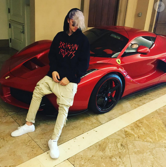 Justin Bieber pose, assis sur sa Ferrari rouge, et présente sa nouvelle coupe de cheveux, le 16 janvier 2016.