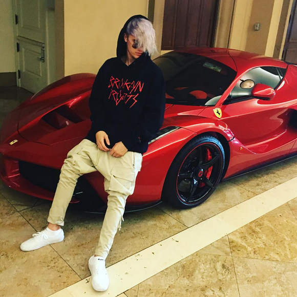 Justin Bieber pose, assis sur sa Ferrari rouge, et présente sa nouvelle coupe de cheveux, le 16 janvier 2016.