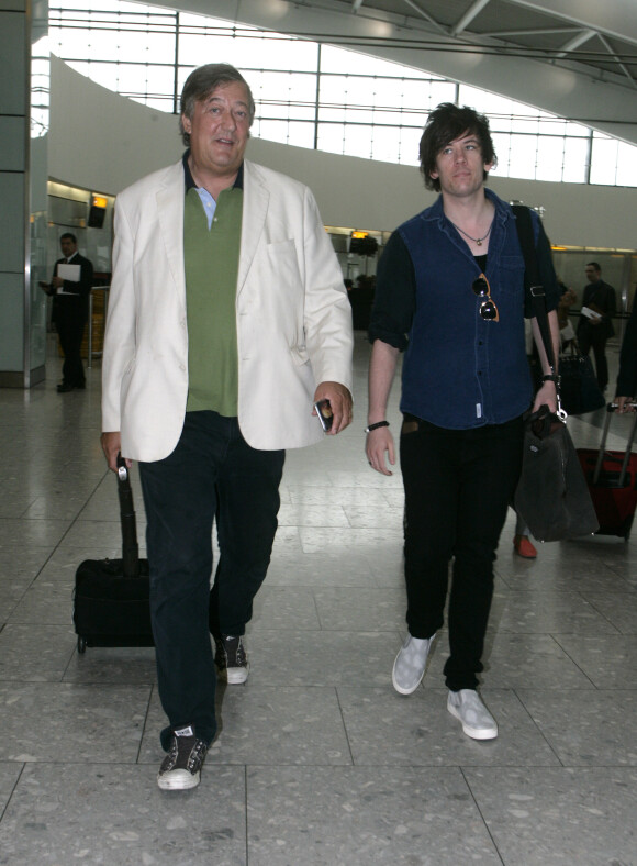 Exclusif - Stephen Fry et son compagnon Elliott Spencer arrivent à l'aéroport Heathrow de Londres pour prendre un avion. Le 16 juillet 2015