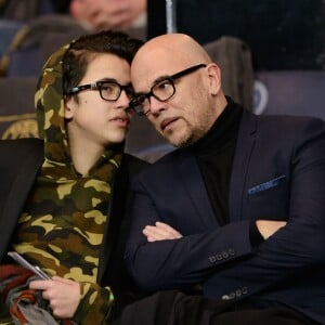 Pascal Obispo et son fils Sean lors de la rencontre entre le PSG et Chelsea en 8e de finale de la Ligue des champions, au Parc des Princes à Paris le 16 février 2016