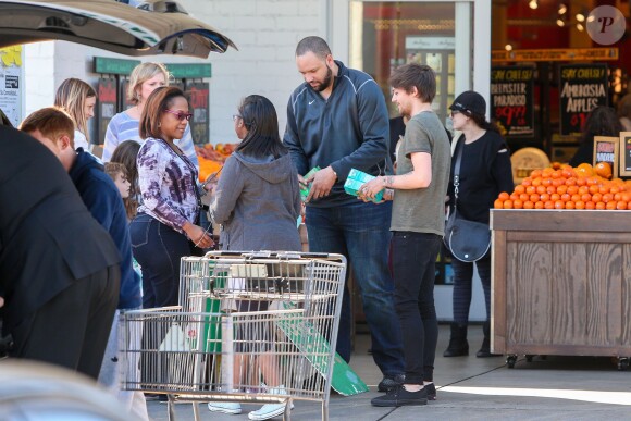 Louis Tomlinson de One Direction participe a une distribution de vivres pour une oeuvre de charité et pose avec ses fans à Los Angeles le 21 février 2016.