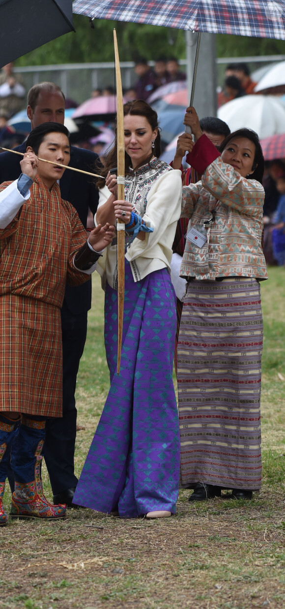 Kate Catherine Middleton, duchesse de Cambridge, s'exerce au tir à l'arc sous l'oeil amusé du prince William, duc de Cambridge, à Thimphou, à l'occasion de leur voyage officiel au Bhoutan. Le 14 avril 2016  14 April 2016. The Duke and Duchess of Cambridge in Bhutan at Thimphu's open-air archery venue after watching a display both of them tried Archery and a Darts Game.14/04/2016 - Thimphu