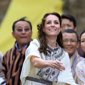 Kate Catherine Middleton, duchesse de Cambridge, s'exerce au tir à l'arc sous l'oeil amusé du prince William, duc de Cambridge, à Thimphou, à l'occasion de leur voyage officiel au Bhoutan. Le 14 avril 2016  The Duchess of Cambridge throwing a dart at an archery event in Thimphu, Bhutan, during day five of the royal tour to India and Bhutan.14/04/2016 - Paro