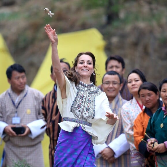 Kate Catherine Middleton, duchesse de Cambridge, s'exerce au tir à l'arc sous l'oeil amusé du prince William, duc de Cambridge, à Thimphou, à l'occasion de leur voyage officiel au Bhoutan. Le 14 avril 2016  The Duchess of Cambridge throwing a dart at an archery event in Thimphu, Bhutan, during day five of the royal tour to India and Bhutan.14/04/2016 - Paro