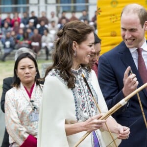 Kate Catherine Middleton, duchesse de Cambridge, s'exerce au tir à l'arc sous l'oeil amusé du prince William, duc de Cambridge, à Thimphou, à l'occasion de leur voyage officiel au Bhoutan. Le 14 avril 2016  14 April 2016. The Duke and Duchess of Cambridge arrive in Bhutan for a two-day visit. One of their engagements took them to the National Stadium where there were some games going on. Both Prince William and Catherine tried their hand at archery and dart throwing.14/04/2016 - Thimphou