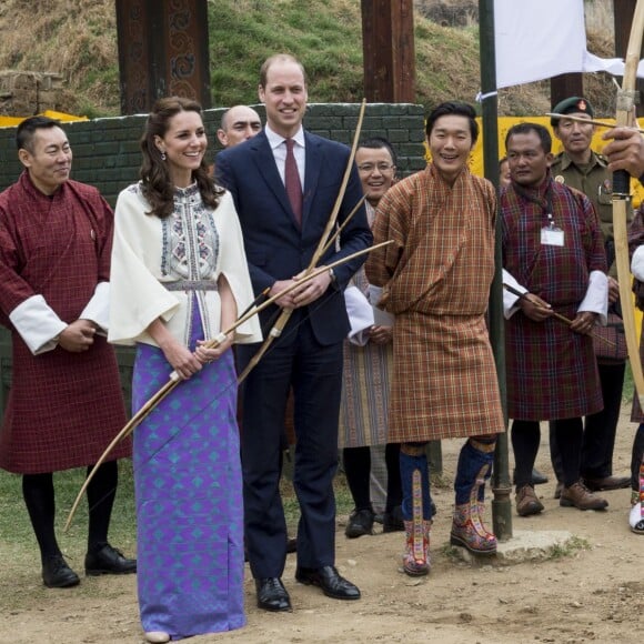 Kate Catherine Middleton, duchesse de Cambridge, s'exerce au tir à l'arc sous l'oeil amusé du prince William, duc de Cambridge, à Thimphou, à l'occasion de leur voyage officiel au Bhoutan. Le 14 avril 2016  14 April 2016. The Duke and Duchess of Cambridge arrive in Bhutan for a two-day visit. One of their engagements took them to the National Stadium where there were some games going on. Both Prince William and Catherine tried their hand at archery and dart throwing.14/04/2016 - Thimphou