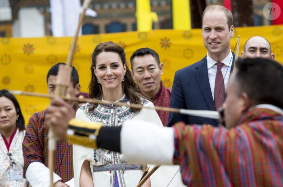 Kate Catherine Middleton, duchesse de Cambridge, s'exerce au tir à l'arc sous l'oeil amusé du prince William, duc de Cambridge, à Thimphou, à l'occasion de leur voyage officiel au Bhoutan. Le 14 avril 2016  14 April 2016. The Duke and Duchess of Cambridge arrive in Bhutan for a two-day visit. One of their engagements took them to the National Stadium where there were some games going on. Both Prince William and Catherine tried their hand at archery and dart throwing.14/04/2016 - Thimphou
