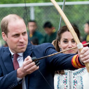 Kate Catherine Middleton, duchesse de Cambridge, s'exerce au tir à l'arc sous l'oeil amusé du prince William, duc de Cambridge, à Thimphou, à l'occasion de leur voyage officiel au Bhoutan. Le 14 avril 2016  14 April 2016. The Duke and Duchess of Cambridge arrive in Bhutan for a two-day visit. One of their engagements took them to the National Stadium where there were some games going on. Both Prince William and Catherine tried their hand at archery and dart throwing.14/04/2016 - Thimphou