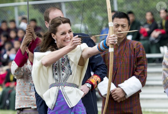 Kate Catherine Middleton, duchesse de Cambridge, s'exerce au tir à l'arc sous l'oeil amusé du prince William, duc de Cambridge, à Thimphou, à l'occasion de leur voyage officiel au Bhoutan. Le 14 avril 2016  14 April 2016. The Duke and Duchess of Cambridge arrive in Bhutan for a two-day visit. One of their engagements took them to the National Stadium where there were some games going on. Both Prince William and Catherine tried their hand at archery and dart throwing.14/04/2016 - Thimphou