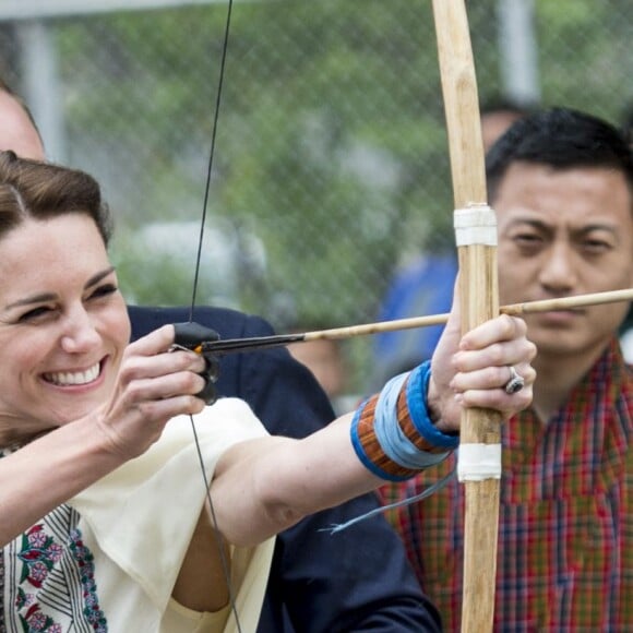 Kate Catherine Middleton, duchesse de Cambridge, s'exerce au tir à l'arc sous l'oeil amusé du prince William, duc de Cambridge, à Thimphou, à l'occasion de leur voyage officiel au Bhoutan. Le 14 avril 2016  14 April 2016. The Duke and Duchess of Cambridge arrive in Bhutan for a two-day visit. One of their engagements took them to the National Stadium where there were some games going on. Both Prince William and Catherine tried their hand at archery and dart throwing.14/04/2016 - Thimphou