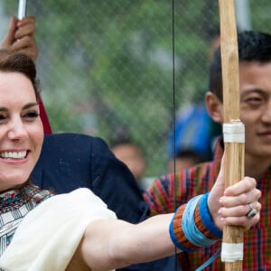 Kate Catherine Middleton, duchesse de Cambridge, s'exerce au tir à l'arc sous l'oeil amusé du prince William, duc de Cambridge, à Thimphou, à l'occasion de leur voyage officiel au Bhoutan. Le 14 avril 2016  14 April 2016. The Duke and Duchess of Cambridge arrive in Bhutan for a two-day visit. One of their engagements took them to the National Stadium where there were some games going on. Both Prince William and Catherine tried their hand at archery and dart throwing.14/04/2016 - Thimphou