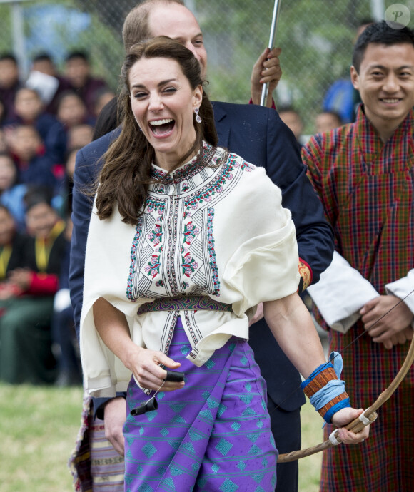 Kate Catherine Middleton, duchesse de Cambridge, s'exerce au tir à l'arc sous l'oeil amusé du prince William, duc de Cambridge, à Thimphou, à l'occasion de leur voyage officiel au Bhoutan. Le 14 avril 2016  14 April 2016. The Duke and Duchess of Cambridge arrive in Bhutan for a two-day visit. One of their engagements took them to the National Stadium where there were some games going on. Both Prince William and Catherine tried their hand at archery and dart throwing.14/04/2016 - Thimphou