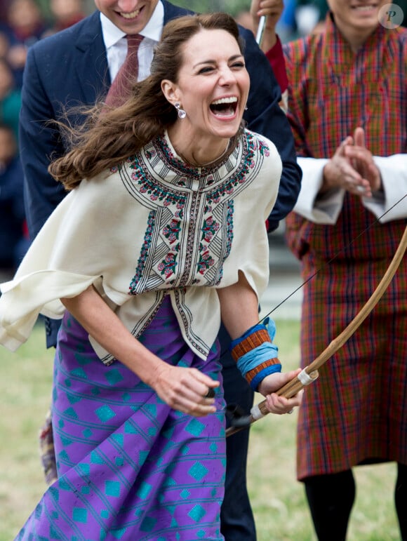 Kate Catherine Middleton, duchesse de Cambridge, s'exerce au tir à l'arc sous l'oeil amusé du prince William, duc de Cambridge, à Thimphou, à l'occasion de leur voyage officiel au Bhoutan. Le 14 avril 2016  14 April 2016. The Duke and Duchess of Cambridge arrive in Bhutan for a two-day visit. One of their engagements took them to the National Stadium where there were some games going on. Both Prince William and Catherine tried their hand at archery and dart throwing.14/04/2016 - Thimphou
