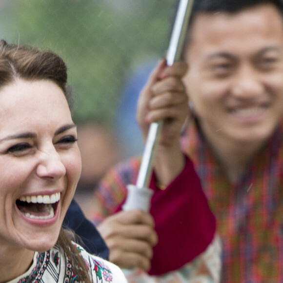Kate Catherine Middleton, duchesse de Cambridge, s'exerce au tir à l'arc sous l'oeil amusé du prince William, duc de Cambridge, à Thimphou, à l'occasion de leur voyage officiel au Bhoutan. Le 14 avril 2016  14 April 2016. The Duke and Duchess of Cambridge arrive in Bhutan for a two-day visit. One of their engagements took them to the National Stadium where there were some games going on. Both Prince William and Catherine tried their hand at archery and dart throwing.14/04/2016 - Thimphou