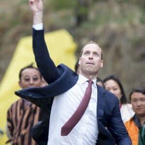 Kate Catherine Middleton, duchesse de Cambridge, s'exerce au tir à l'arc sous l'oeil amusé du prince William, duc de Cambridge, à Thimphou, à l'occasion de leur voyage officiel au Bhoutan. Le 14 avril 2016  14 April 2016. The Duke and Duchess of Cambridge arrive in Bhutan for a two-day visit. One of their engagements took them to the National Stadium where there were some games going on. Both Prince William and Catherine tried their hand at archery and dart throwing.14/04/2016 - Thimphou