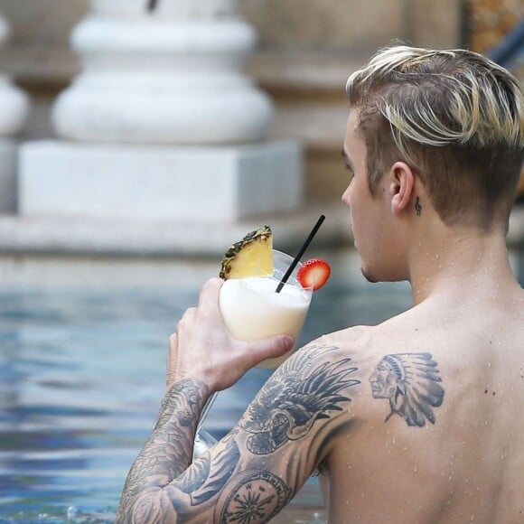 Exclusif - Prix spécial - Justin Bieber se relaxe avec des amis au bord de la piscine de la 'Versace Mansion’ en buvant un cocktail à Miami, le 9 décembre 2015  For germany call for price Exclusive - Pop star Justin Bieber shows off his fit physique and tattoos while cooling off at the Versace Mansion in Miami, Florida on December 9, 2015. Justin, who recently returned from London, was seen enjoying a frozen cocktail with friends at the famous luxury hotel.09/12/2015 - Miami