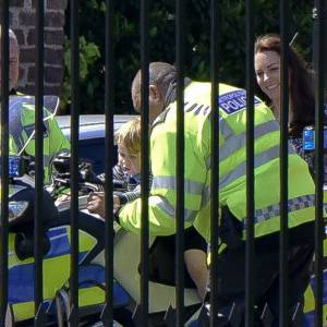 Le prince George de Cambridge est monté sur une moto de la police métropolitaine de Londres le 24 mai 2016 à Kensington Palace, sous les yeux de sa maman Kate Middleton, avec la princesse Charlotte en poussette, après avoir regardé la princesse Anne décoller en hélicoptère pour partir en mission.