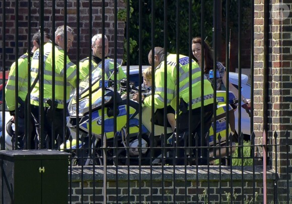 Le prince George de Cambridge est monté sur une moto de la police métropolitaine de Londres le 24 mai 2016 à Kensington Palace, sous les yeux de sa maman Kate Middleton, avec la princesse Charlotte en poussette, après avoir regardé la princesse Anne décoller en hélicoptère pour partir en mission.