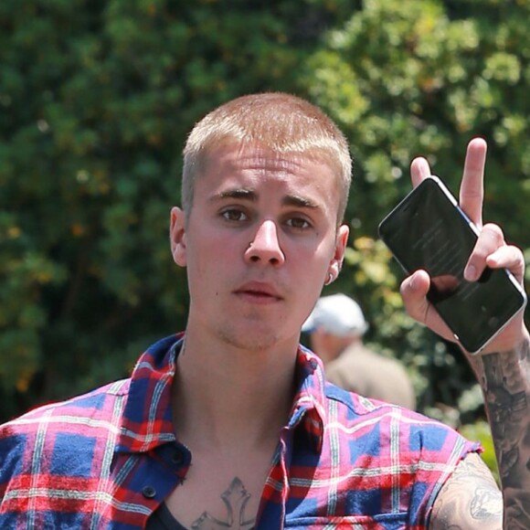 Justin Bieber salue et pose pour les photographes dans les rues de Los Angeles, le 27 mai 2016