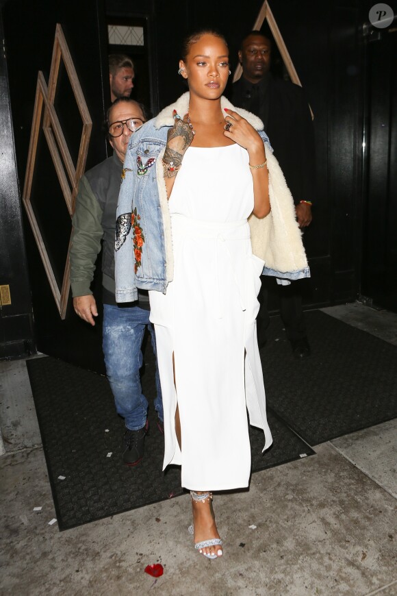 Rihanna de sortie à Los Angeles, porte une veste en denim brodée et doublée en shearling Gucci, une robe blanche Adam Selma (collection printemps 2016) et des sandales Manolo Blahnik par Rihanna (modèle RIH VI'S). Le 10 juin 2016.