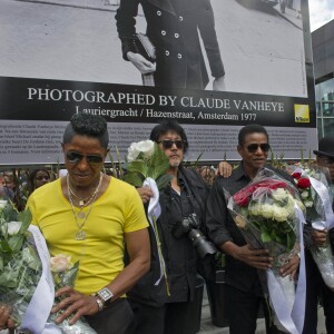 Les frères Jackson rendent hommage à Michael Jackson devant une photo de 1977 du chanteur du photographe Claude Vanheye installée au Gustav Mahlersquare à Amsterdam, le 30 juillet 2014.