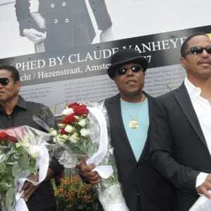 Les frères Jackson rendent hommage à Michael Jackson devant une photo de 1977 du chanteur du photographe Claude Vanheye installée au Gustav Mahlersquare à Amsterdam, le 30 juillet 2014.